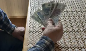 Dłoń trzyma banknoty. Czy to zapowiedź wyższego wskaźnika waloryzacji emerytur 2026?
