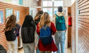 Grupa studentów z plecakami idzie korytarzem. Myślą o przyszłości: status studenta a umowa o pracę.
