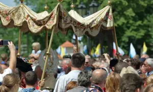 Procesja Bożego Ciała. Czy to dzień wolny od pracy? Ludzie obserwują, niektórzy filmują telefonami.