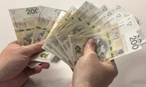 Dłonie trzymają plik banknotów 200 zł. Zastanawiasz się, czy alimenty można odliczyć od podatku?
