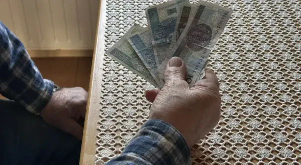 Dłoń trzyma banknoty. Czy to zapowiedź wyższego wskaźnika waloryzacji emerytur 2026?