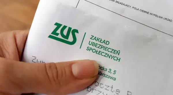 Dłoń trzyma dokument ZUS. Może to być pismo dotyczące sześciomiesięczną odprawa emerytalna.