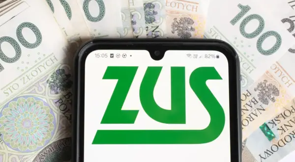 Pierwsza wypłata emerytury po raz pierwszy! Na ekranie telefonu logo ZUS, a w tle polskie stuzłotówki.