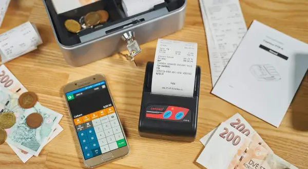 Kasa fiskalna, smartfon z kalkulatorem, banknoty i monety. Kto musi mieć kasę fiskalną? Sprawdź przepisy!