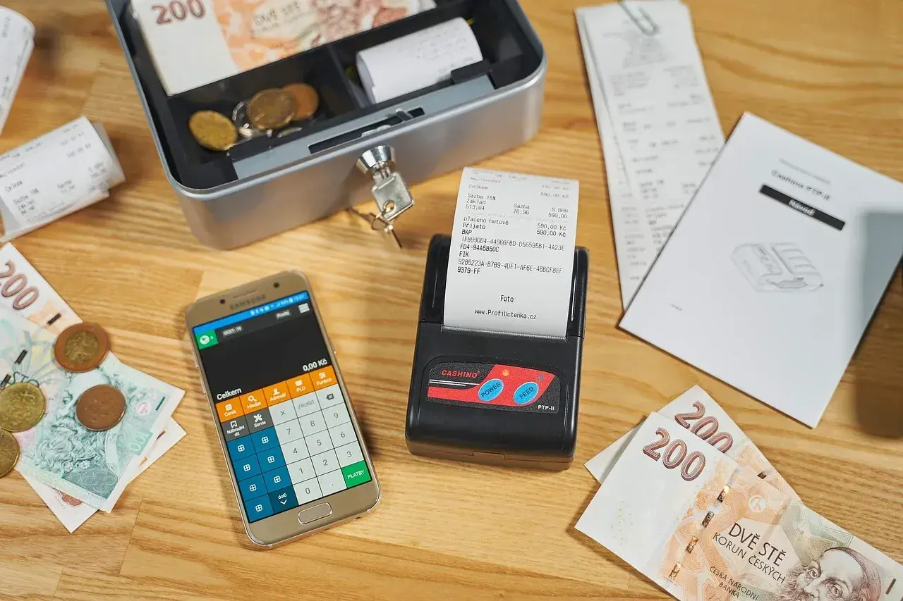 Kasa fiskalna, smartfon z kalkulatorem, banknoty i monety. Kto musi mieć kasę fiskalną? Sprawdź przepisy!