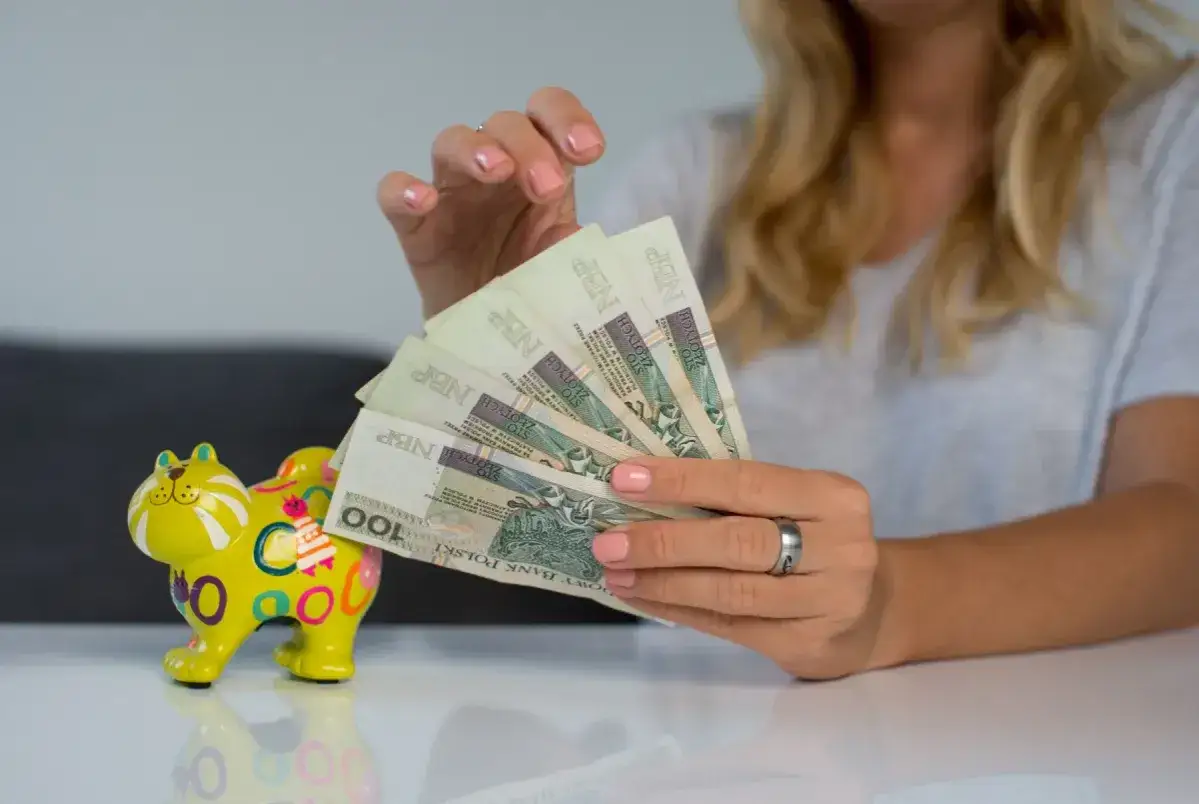 Samotna matka liczy pieniądze, zastanawiając się, ile dostaje na utrzymanie.
