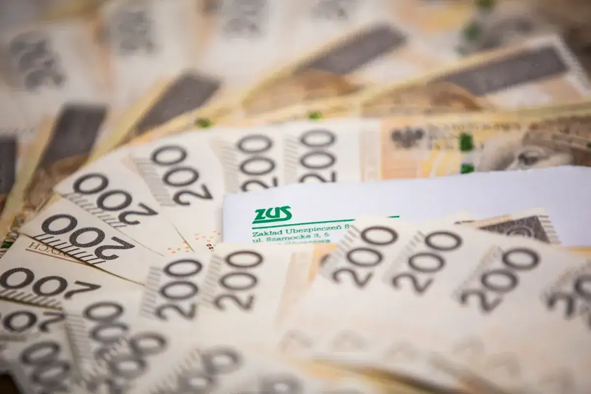 Złote banknoty 200 zł ułożone wachlarzowo, z dokumentem ZUS. Ofe po zmarłym mogą być wypłacane przez ZUS.