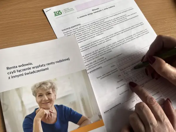 Kobieta wypełnia wniosek ZUS o ustalenie zbiegu świadczeń z rentą rodzinna, pytając, czy renta rodzinna wlicza się do dochodu.
