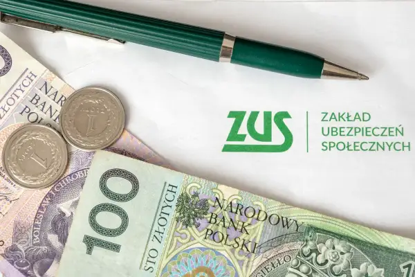 ZUS i polskie złotówki, gotowe do opłacenia składek. Zielony długopis czeka na podpis.