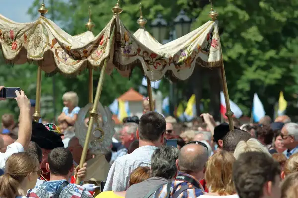 Procesja Bożego Ciała. Czy to dzień wolny od pracy? Ludzie obserwują, niektórzy filmują telefonami.